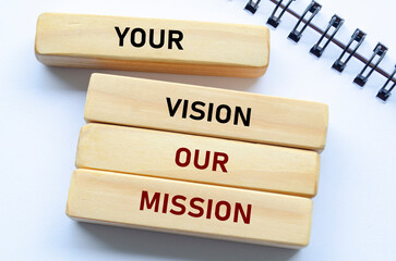 Your vision our mission text on wooden blocks and notebook emphasizes alignment with client goals and shared purpose