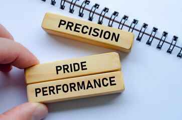 Precision through performance shown on wooden blocks over a notepad signifies the importance of accuracy in achieving success