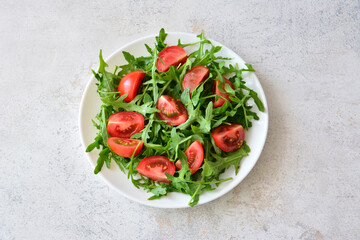 Fresh Tomato and Arugula Salad on a White Plate top view