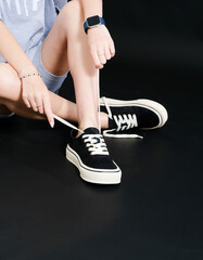 Young woman wearing in an  comfortable clothes and sneakers resting on a floor
