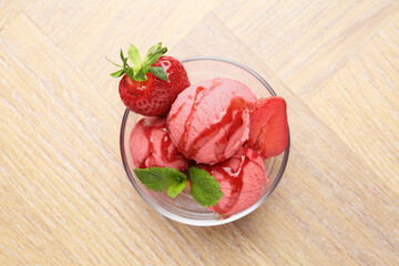 Refreshing sorbet with syrup, strawberries and mint in bowl on wooden table, top view