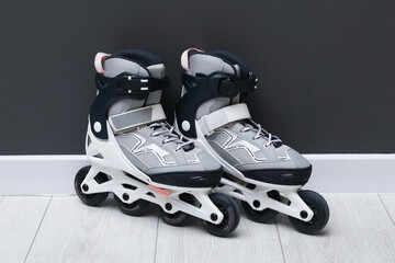 Pair of roller skates on floor near black wall
