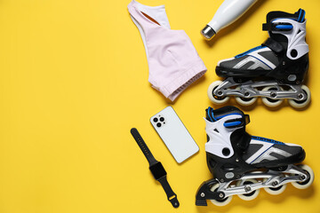Fototapeta premium Flat lay composition with roller skates on yellow background. Space for text