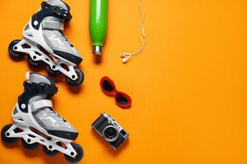 Flat lay composition with roller skates on orange background. Space for text