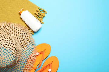 Flat lay composition with beach towel and other summer accessories on light blue background. Space...