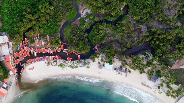 Aerial top view down of a Caribbean paradise beach with a river channel and fishing boats