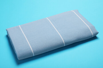 Striped beach towel on light blue background, closeup