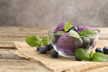 Tasty sorbet with blueberries and mint served on wooden table, closeup. Space for text