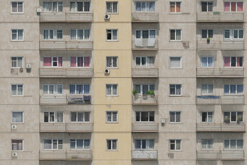 old apartment building facade with worn balconies and faded paint in urban setting