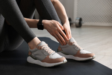Sports injury. Young woman suffering from leg pain in fitness studio, closeup