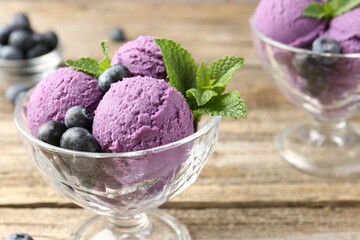 Tasty sorbet with blueberries and mint in dessert bowls on wooden table, closeup