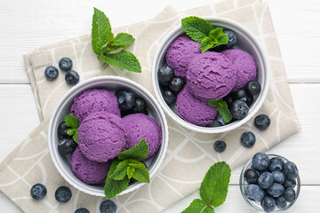 Tasty sorbet with blueberries and mint in bowls on white wooden table, flat lay