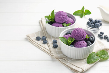 Tasty sorbet with blueberries and mint in bowls on white wooden table, closeup