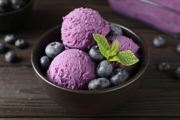 Tasty sorbet with blueberries and mint in bowl on wooden table, closeup