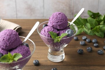 Tasty sorbet with blueberries and mint in dessert bowls on wooden table, closeup