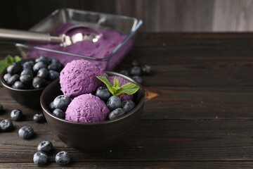 Tasty sorbet with blueberries and mint in bowl on wooden table, closeup. Space for text