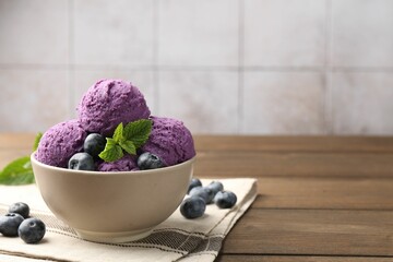 Tasty sorbet with blueberries and mint in bowl on wooden table, closeup. Space for text