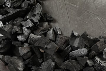 Pieces of black coals on grey table, flat lay
