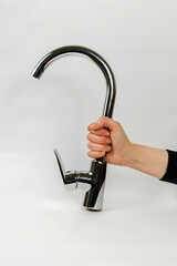 Hand Firmly Gripping Shiny Metal Faucet Against White