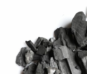 Pieces of black coals on white background, top view