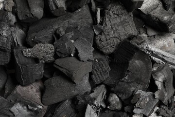 Pieces of black coals as background, top view