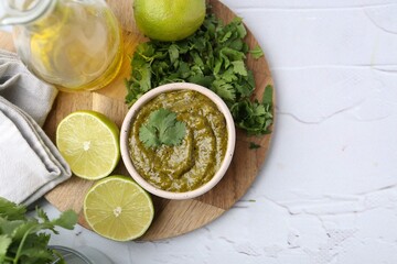 Tasty sauce with cilantro and other ingredients on white table, flat lay. Space for text