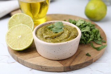 Tasty sauce with cilantro and other ingredients on white table, closeup