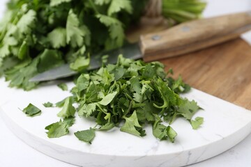 Fresh green cilantro and knife on table, closeup