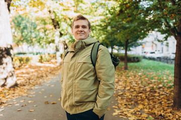 Calm happy 30s Man Relaxing in Autumn Park Outdoors. Traveler. Falling time. Smiling man in casual clothing standing outdoor