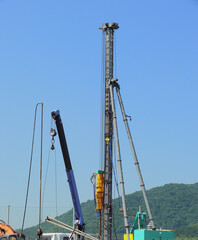 Arms of the heavy machines in operation at the construction site.