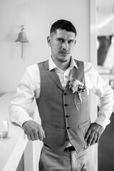 portrait of the groom in a gray suit and an orange vest
