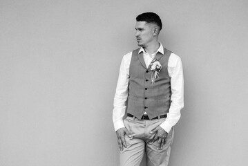 portrait of the groom in a gray suit and an orange vest