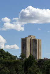 view of tall apartment building in queens with big puffy white clouds in the background (co-op real estate condo cooperative apartments public housing) balcony balconies pre-war old house home forest