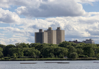 view of tall apartment building in queens with big puffy white clouds in the background (co-op real estate condo cooperative apartments public housing) balcony balconies pre-war old house home forest