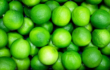 Food background texture, many fresh green lime citrus fruit, top view.