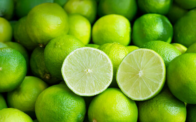 Natural fresh lime cut in half with many whole lime fruits , food background texture.