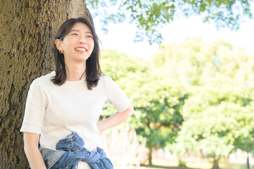 公園で微笑む半袖を着た日本人女性