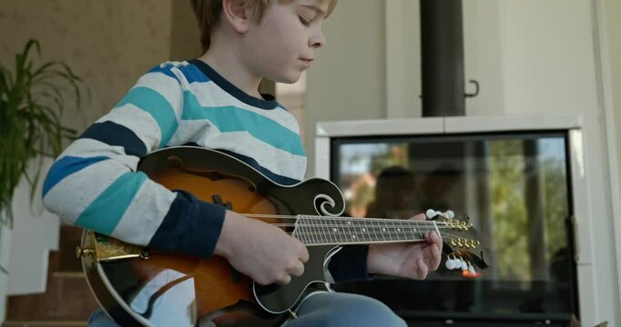Caucasian Kid Play Mandolin at Home. European Boy Practice Music 4K 10-bit