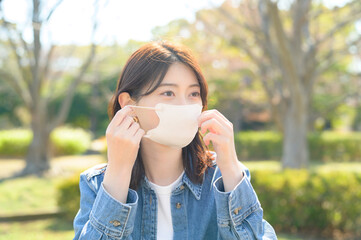 公園でマスクをつける日本人女性