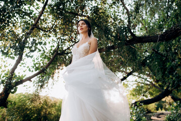 bride blonde girl with a bouquet in the forest