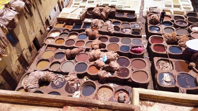 Workers dying leathers in traditional way in Chouara Tannery, Fez, Morocco