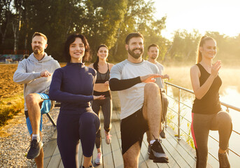 Group of fit and active people doing sport exercising in nature. Happy smiling men and women in...