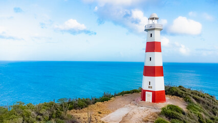 Red and White Lighthouse by the Ocean on a Sunny Day