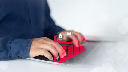 Businessman typing on laptop with red expense graph and asset icons, representing cost analysis,...