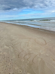 Sand on the Baltic Sea beach in Mrzezyno in Poland after being washed by a wave in close-up as a background