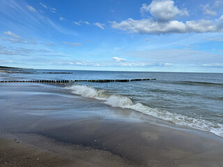 Empty Baltic beach in the Mrzezyno area in Poland with characteristic breakwaters made of pegs