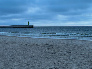 The beach and Baltic Sea near the entrance to the port in Mrzezyno in Poland