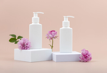 containers for skin care products on a white podium and rose flowers on a beige background