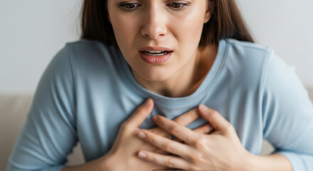 Close-up of a woman experiencing chest pain, heart attack, infarction or cardiac arrest