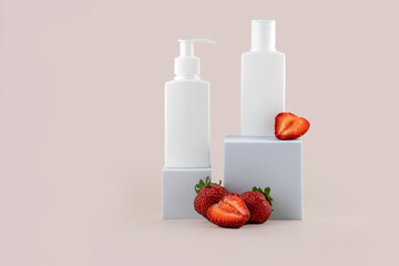 containers for skin care products on a white podium and strawberries on a pink background